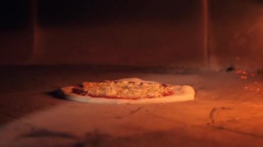 Çiğ pizza hamuru ve malzemeler fırında pişiyor.