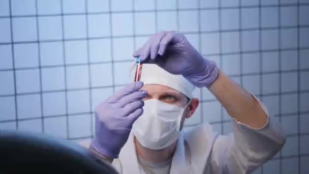 Scientifique masqué regarde un échantillon de coronavirus en laboratoire — Video