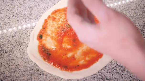 Cozinheiro coloca queijo na massa coberta com molho fazendo pizza — Vídeo de Stock
