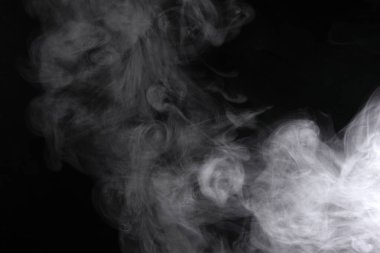 Siyah arka planda yayılan duman bulutları.