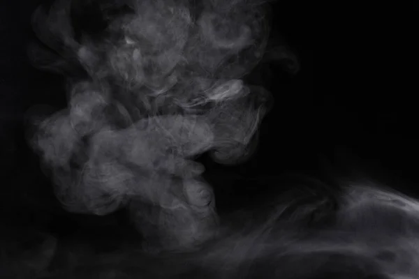 Des bouffées de fumée se propagent sur fond noir . — Photo