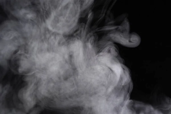 Puffs de humo extendidos sobre un fondo negro . —  Fotos de Stock