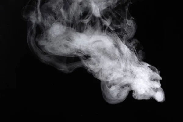 Rauchschwaden breiten sich auf schwarzem Hintergrund aus. — Stockfoto