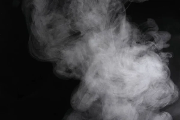 Духи дыма распространяются на черном фоне . — стоковое фото