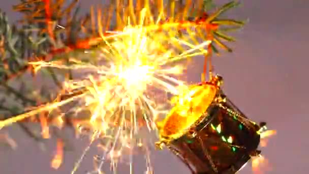 Buon Natale e felice anno nuovo! Candela del Bengala accesa. Brillanti scintille volano intorno ed esplodono con piccoli fuochi d'artificio . — Video Stock