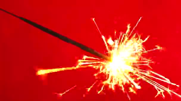Счастливого Рождества и счастливого Нового года! Бенгальская свеча горит. Яркие искры летают и взрываются небольшими фейерверками . — стоковое видео