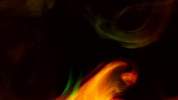Кучеряві повзучі пуфи диму на темному тлі, освітлені світлом з різними кольорами . — стокове відео