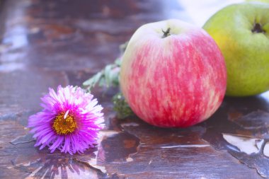 Masada duran güzel kokulu elmalar ve tatlı erikler. Sıcak yaz güneşinde lezzetli meyveler.