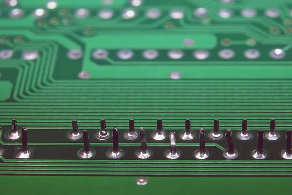 Druga strona zielonej płyty elektronicznej z lutowanymi chipami i komponentami. — Zdjęcie stockowe