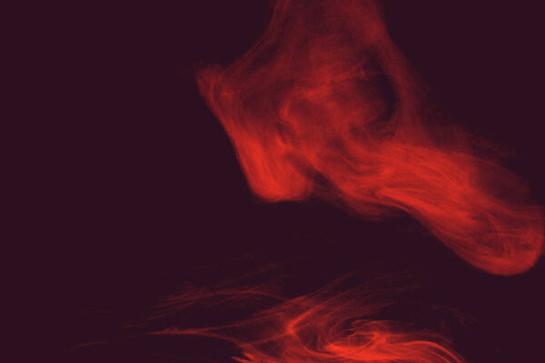 Curls and clouds of colored smoke float against a colored dark background.