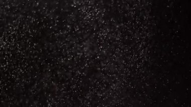 Beyaz kar geceleri yavaş yavaş kıvrılarak kışın donmuş topraklara iniyor. Karanlıkta parlak ışıkta beyaz toz bulutları.