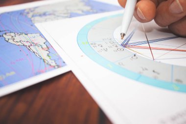Modern bir astrologun işyeri. Bir astrologun aksesuarları. Bilgisayar astrolojik haritaları ve tabloların çıktıları. Astrolojik semboller ve işaretler.