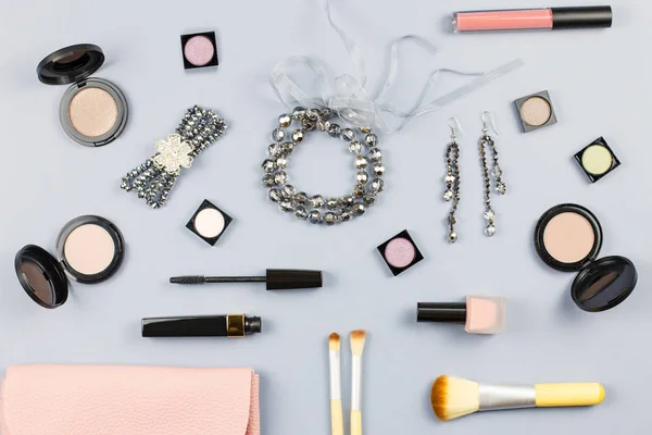 Woman fashion accessories, jewelry and cosmetics on stylish gray background. Flat lay