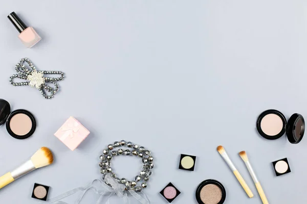 Woman fashion accessories, jewelry and cosmetics on stylish gray background. Flat lay