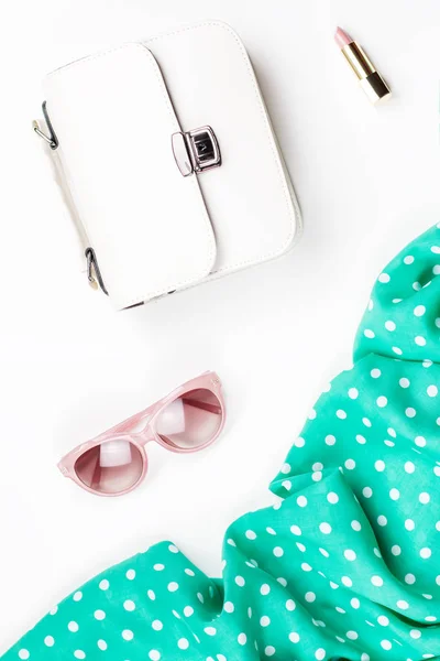 Woman fashion accessories flat lay - white purse, pink sunglasses, lipstick, scarf. Spring concept fashion collection.