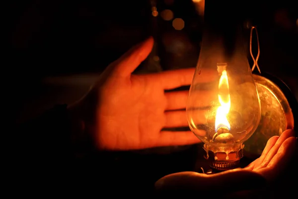 Hands next to oil lamp — ストック写真