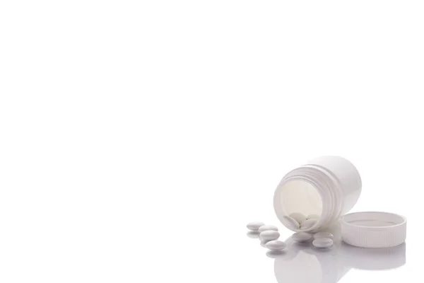 Frasco Com Comprimidos Vertidos Fica Uma Superfície Espelho Fundo Branco — Fotografia de Stock