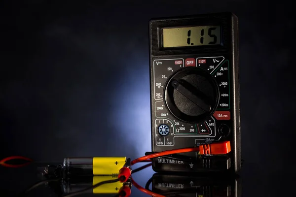 Instrument for measuring electric energy; check the battery charge on a black backlit background.