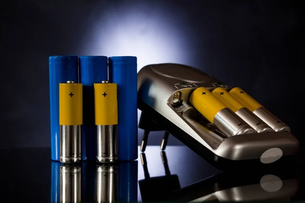 Batterijen Van Verschillende Afmetingen Naast Lader Een Zwarte Achtergrond — Stockfoto