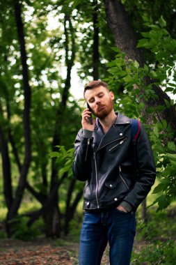 Parktaki telefonda turuncu bıyıklı, buruşuk suratlı bir adam..