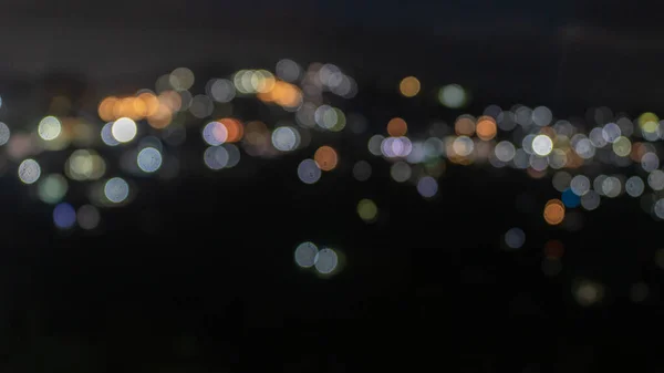 Blurry city lights of a town situated in hill. — Stockfoto