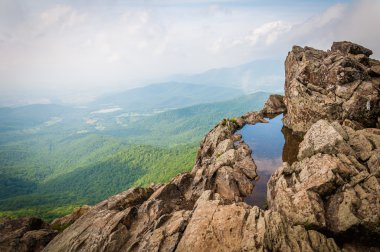 Su birikintisi küçük taşlı adam kayalıklarla ve sisli Bl görünümünü