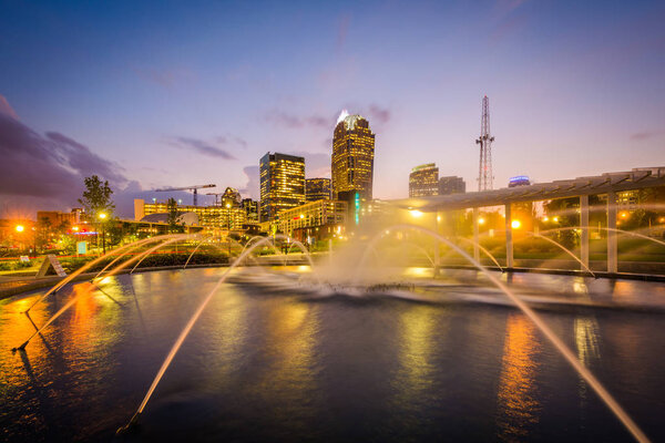 Fountains and the Charlotte skyline at First Ward Park at night,