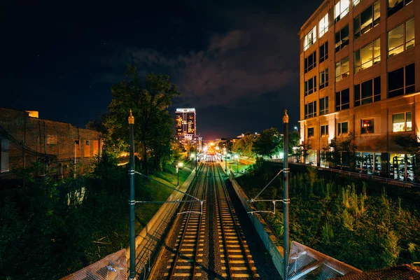 Railroad tracks and buildings at night, in Uptown Charlotte, Nor — Stock Photo, Image