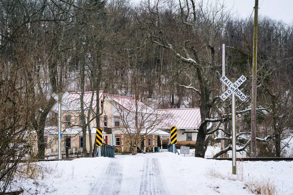 Bridge and railroad crossing along a snow covered country road, — Stock Photo, Image