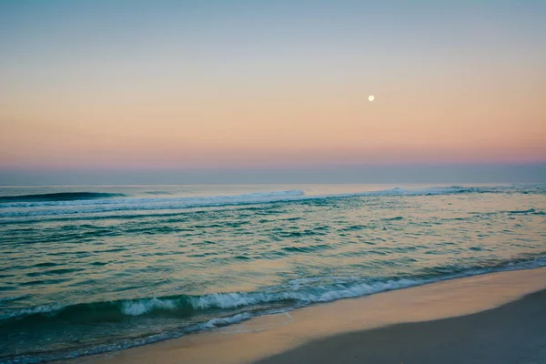Moon over the Gulf of Mexico at sunrise, in Panama City Beach, F