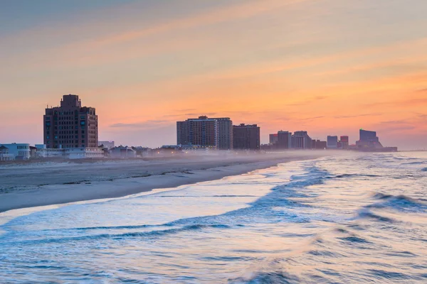 Waves in the Atlantic Ocean and buildings at sunrise, in Ventnor — Stock Photo, Image