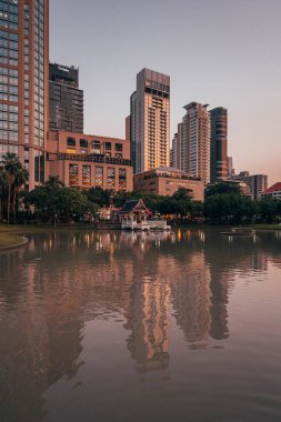 Günbatımında Bencha 'da, Sukhumvit Yolu' nda göl ve modern binalar.