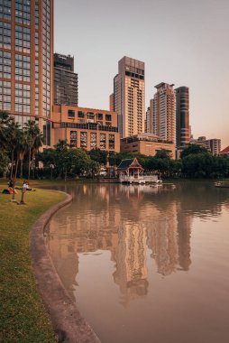 Günbatımında Bencha 'da, Sukhumvit Yolu' nda göl ve modern binalar.