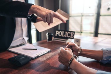 Police officer interrogating suspect or criminal man with handcu