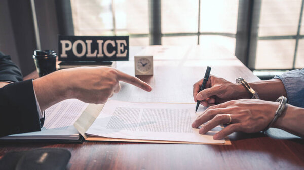 подозреваемый с наручниками на допросе в комнате для допросов Б
