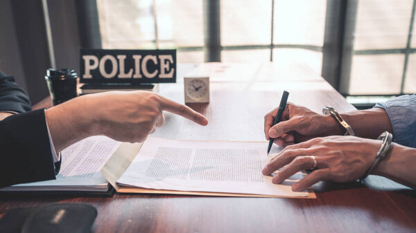 подозреваемый с наручниками на допросе в комнате для допросов Б
