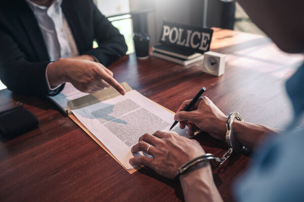 Офицер полиции допрашивает подозреваемого или преступника с гандку
