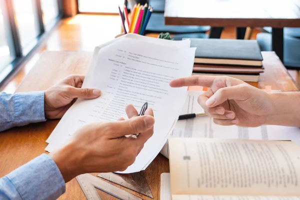 Tutor y estudiantes universitarios que enseñan trabajo escolar y explican la solución de problemas estudiando y leyendo juntos en una mesa en la sala de clases — Foto de Stock