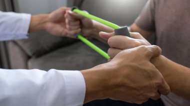 instructor assisting senior doing exercise working out in clinic