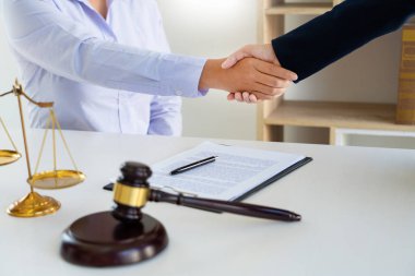 lawyers or attorneys discussing a contract agreement shaking han