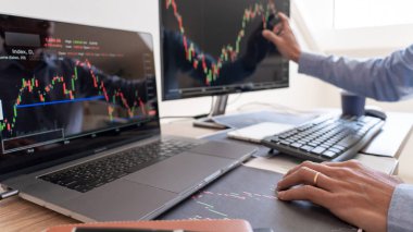 İş adamı, Broker veya tüccarlar borsa birden fazla bilgisayar ekranlarında Forex hakkında konuşan ticaret mali grafik çizelgeleri veri analizi yatırım ticareti