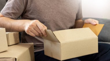 Başlangıçta küçük işletme girişimcisi Sme, dizüstü bilgisayar ve teslimat kutusuyla çalışan Asyalı genç adam, çevrimiçi pazar paketi, Sme e-ticaret danışmanı