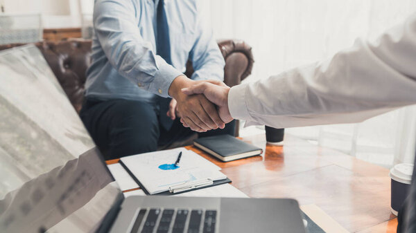 Business Meeting agreement Handshake concept, Hand holding after finishing up dealing project or bargain success at negotiation over office background.