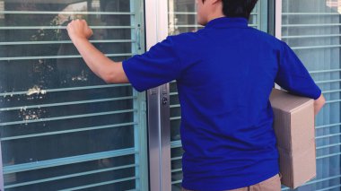 Paket alımını onayladıktan sonra müşteri kontrol listesi imzalaması için mavi üniformalı teslimatçı paket kutusu veriyor. 