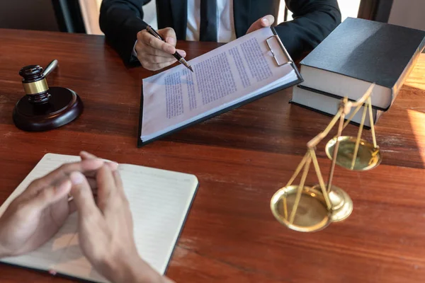Müvekkille çalışan avukat, mahkeme salonundaki yasal mevzuat ile ilgili sözleşme belgelerini tartışıyor, müşterilerine danışmanlık yapıyor..