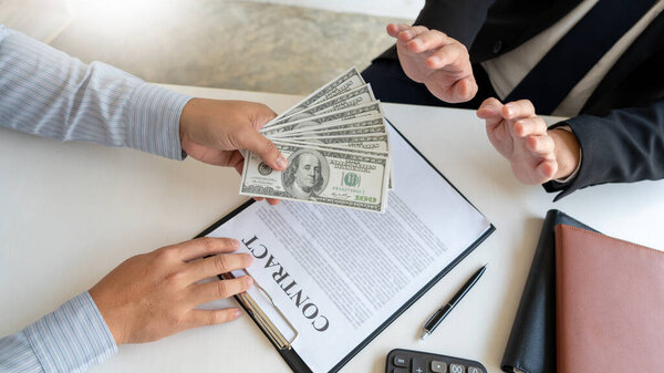Рука бизнесмена отказывается брать наличные деньги у бизнес-партнера по борьбе с коррупцией и продажностью

