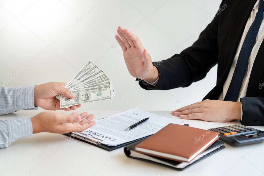Businessman Hand Refusing To Take Bribe cash banknote from business partner, anti-corruption and venalityconcept
