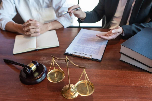 Müvekkille çalışan avukat, mahkeme salonundaki yasal mevzuat ile ilgili sözleşme belgelerini tartışıyor, müşterilerine danışmanlık yapıyor..