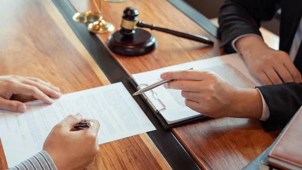 Lawyer working with client discussing contract papers with brass scale about legal legislation in courtroom, consulting to help their customer