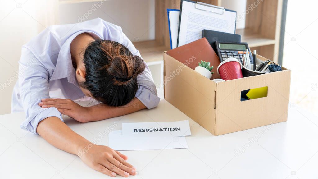 Stress of business woman packing brown cardboard box her belonging after resign and signing cancellation contract letter, Change of job unemployment or resignation concept